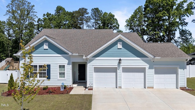 view of front facade featuring an attached garage, driveway, and roof with shingles