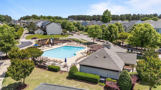 community pool featuring a residential view and central AC unit