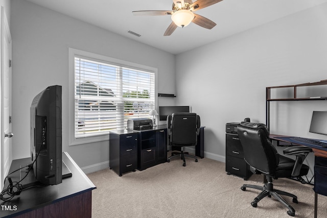 office area featuring baseboards, light carpet, and a ceiling fan
