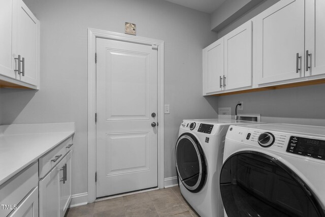 laundry room with separate washer and dryer, cabinet space, and baseboards