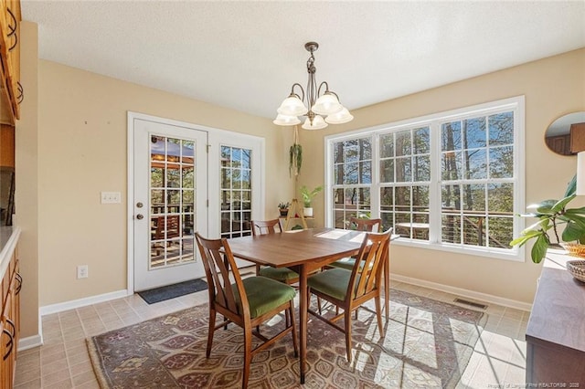 dining space with baseboards, a notable chandelier, light tile patterned flooring, and visible vents