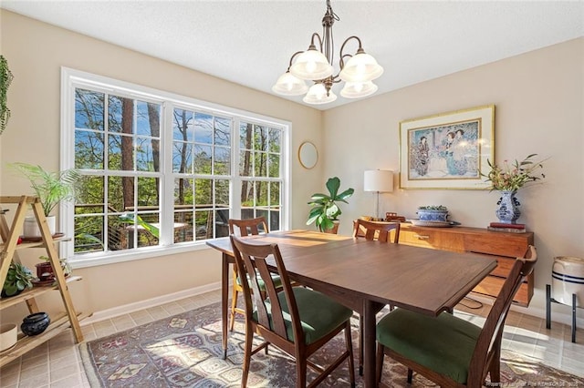 dining area with baseboards, light tile patterned floors, and a notable chandelier