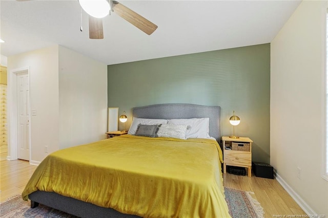 bedroom featuring baseboards, a ceiling fan, and light wood-style flooring