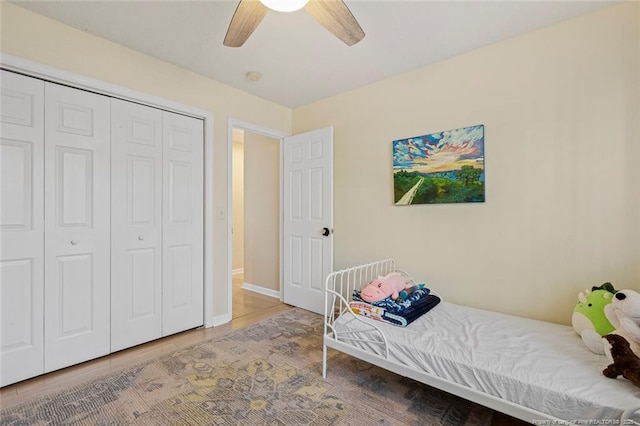 bedroom featuring ceiling fan, baseboards, and a closet