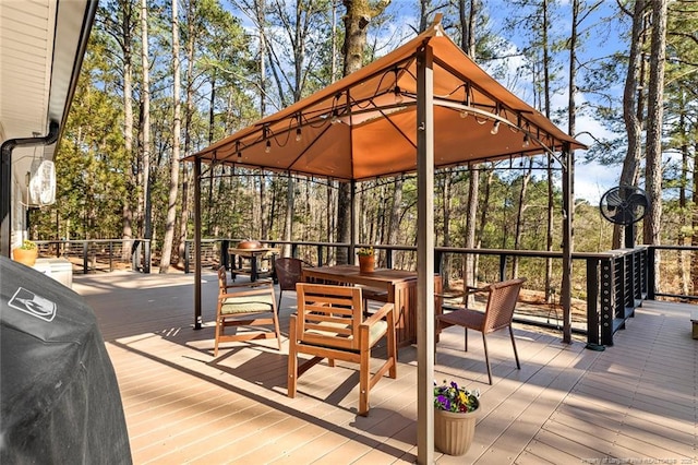 wooden terrace with a gazebo and outdoor dining area