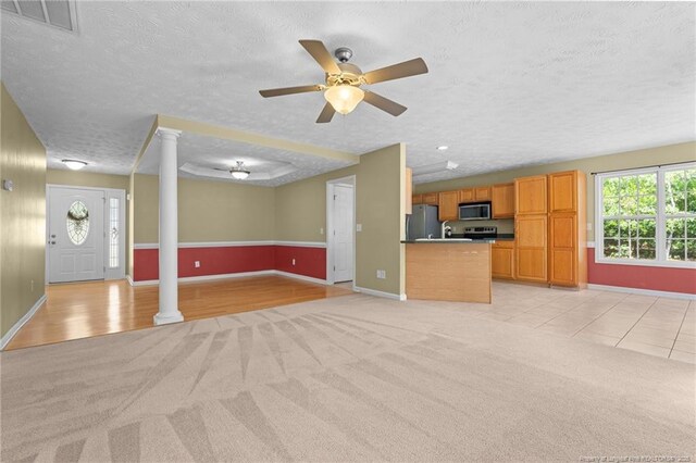 481 Clearwater Harbour, Sanford, NC 27332 - unfurnished living room featuring light colored carpet, a textured ceiling, baseboards, ceiling fan, and ornate columns