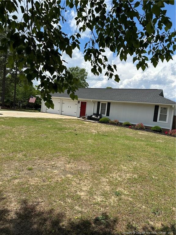 ranch-style house with an attached garage, a front lawn, and driveway