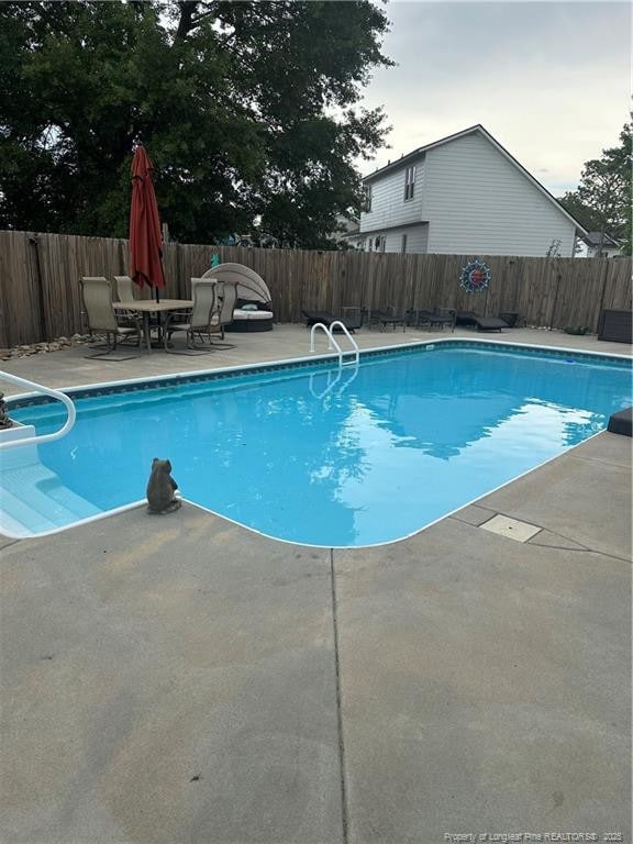 view of swimming pool with a fenced in pool, a fenced backyard, and a patio area