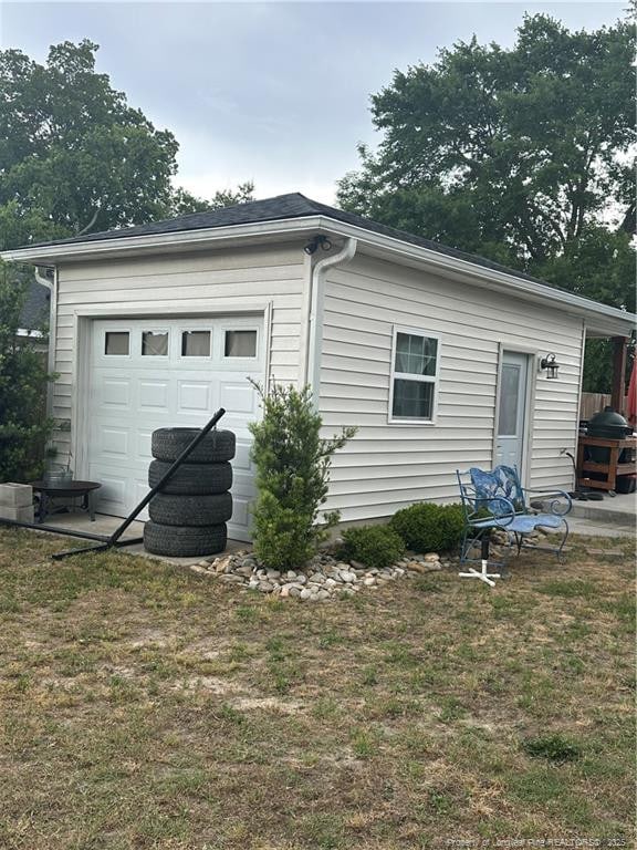 exterior space featuring a garage and a lawn