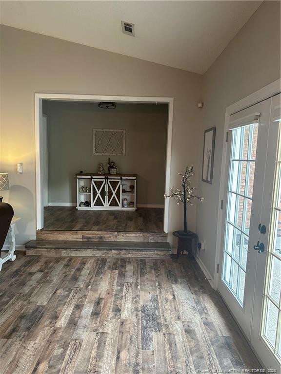 interior space with visible vents, lofted ceiling, wood finished floors, and a healthy amount of sunlight