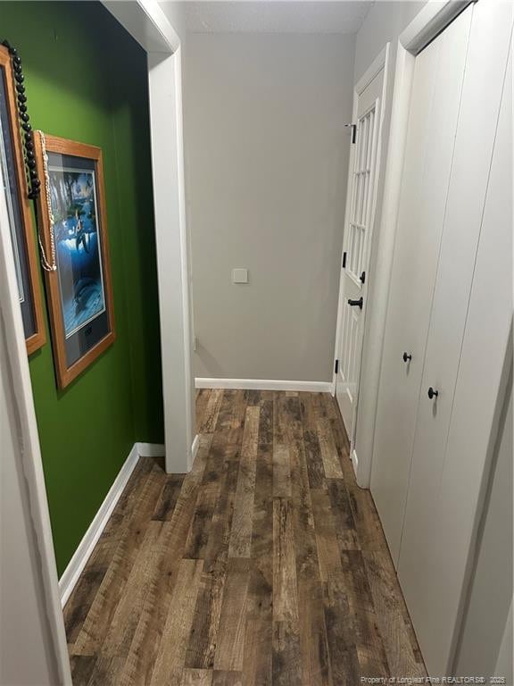 hallway with baseboards and hardwood / wood-style floors