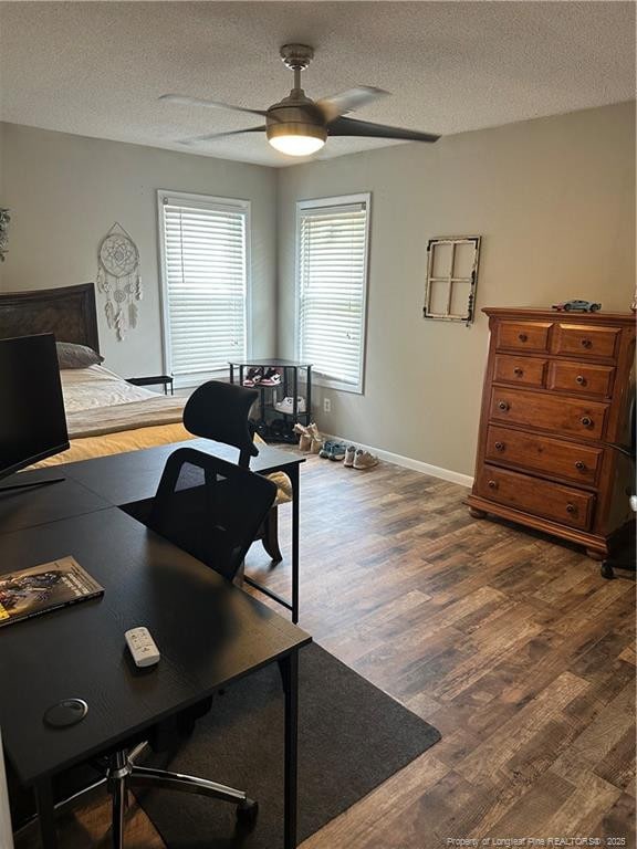 office featuring a textured ceiling, ceiling fan, baseboards, and wood finished floors