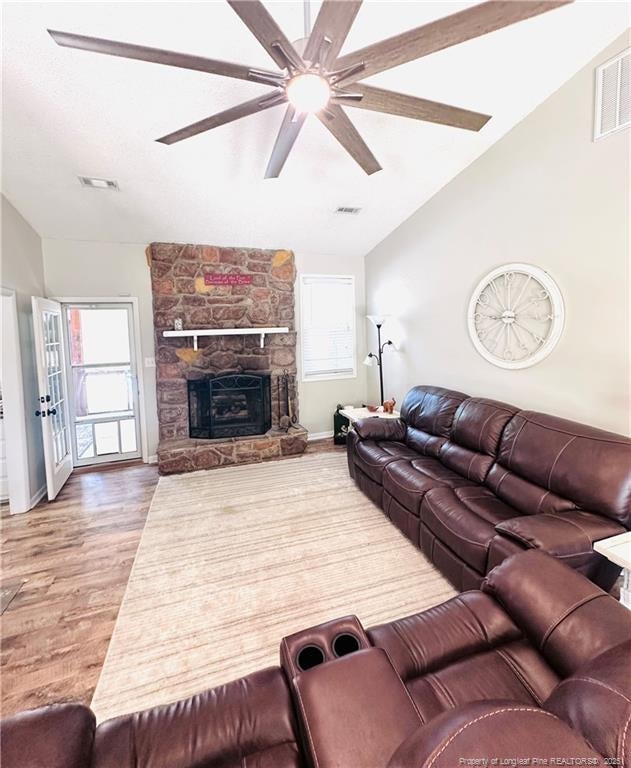 5706 Archer Rd, Hope Mills, NC 28348 - living area with vaulted ceiling, ceiling fan, wood finished floors, plenty of natural light, and a fireplace