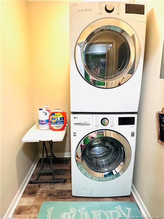 5706 Archer Rd, Hope Mills, NC 28348 - washroom featuring stacked washer / dryer, wood finished floors, and baseboards