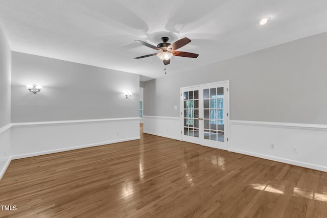 unfurnished room with a ceiling fan, baseboards, french doors, and wood finished floors