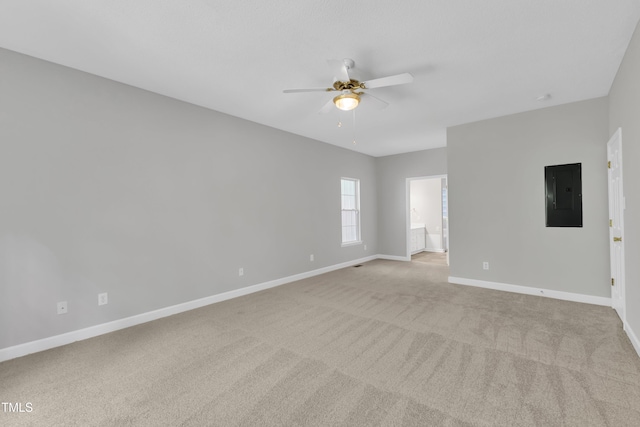 unfurnished room featuring baseboards, ceiling fan, electric panel, and light carpet