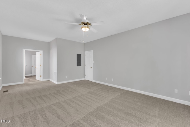 carpeted empty room featuring ceiling fan, visible vents, baseboards, and electric panel