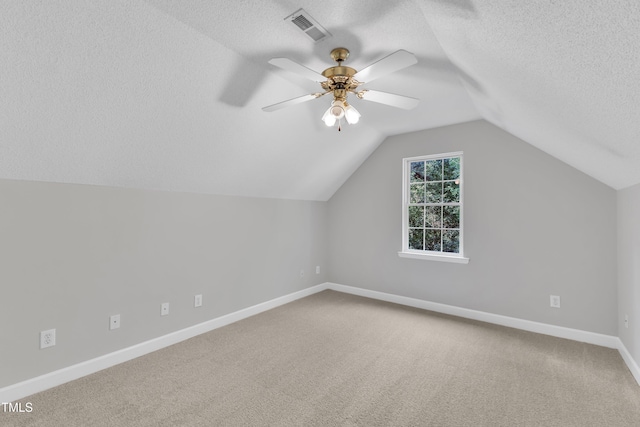 bonus room featuring carpet floors, a textured ceiling, baseboards, lofted ceiling, and visible vents