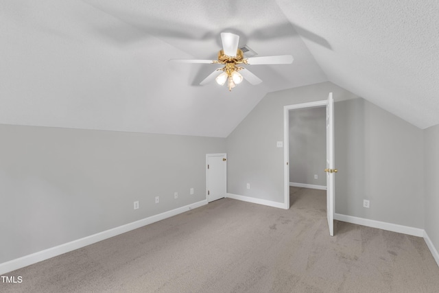 additional living space featuring ceiling fan, carpet flooring, a textured ceiling, and lofted ceiling