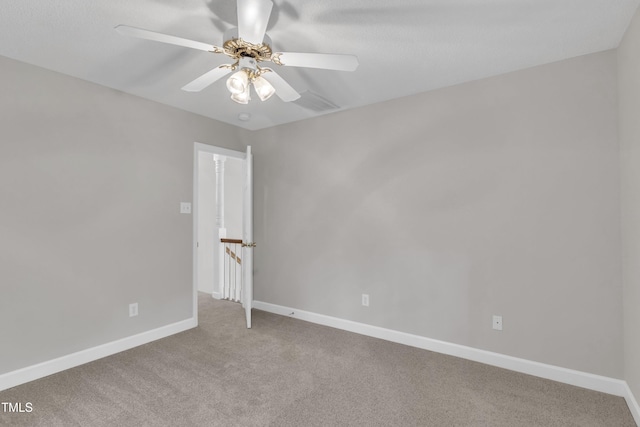 carpeted empty room with ceiling fan and baseboards