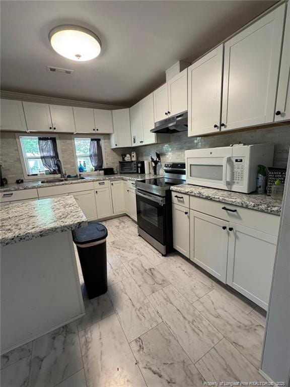kitchen with marble finish floor, under cabinet range hood, white microwave, and stainless steel range with electric cooktop