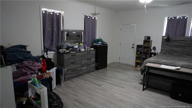bedroom with crown molding and light wood-style floors