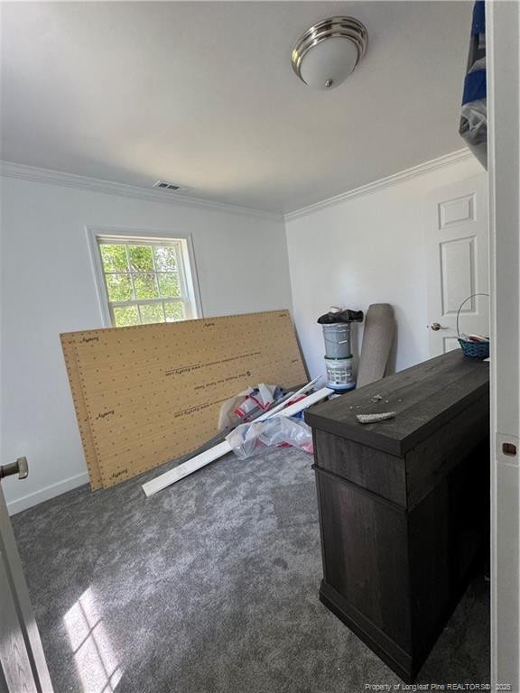 office with crown molding, baseboards, visible vents, and dark carpet