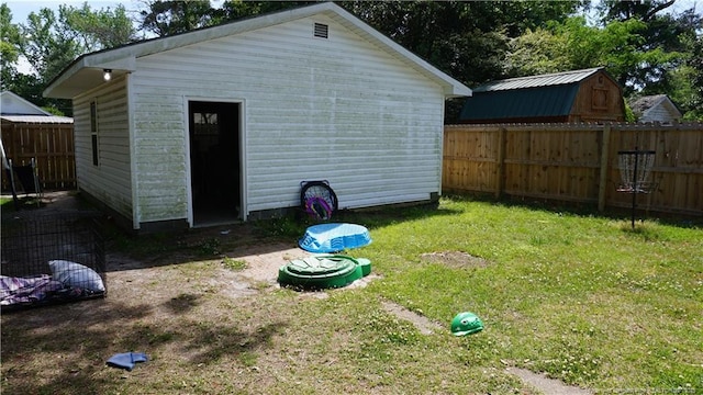 view of outbuilding featuring fence and an outbuilding