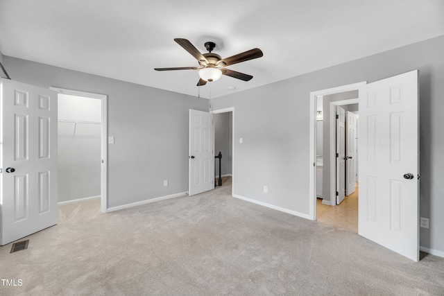6513 Hearthstone Dr, Raleigh, NC 27615 - unfurnished bedroom with light carpet, baseboards, a spacious closet, and a ceiling fan