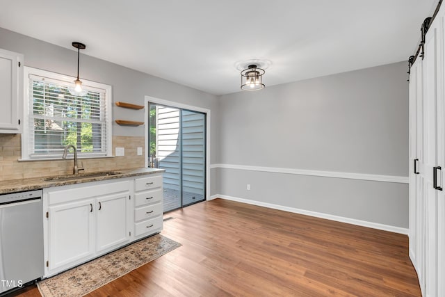 6513 Hearthstone Dr, Raleigh, NC 27615 - kitchen featuring a sink, stainless steel dishwasher, decorative backsplash, light wood-type flooring, and white cabinetry
