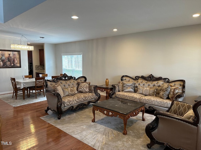 living room with recessed lighting, baseboards, wood finished floors, and an inviting chandelier