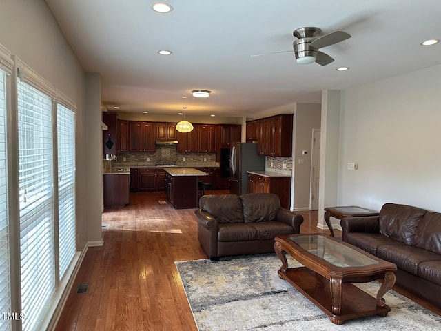 living room featuring recessed lighting, ceiling fan, visible vents, and dark wood-style floors