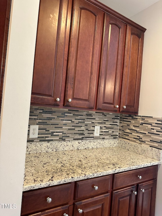 kitchen featuring backsplash and light stone countertops
