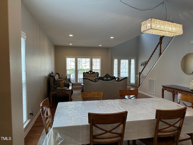 dining area featuring visible vents, wood finished floors, recessed lighting, a chandelier, and stairs