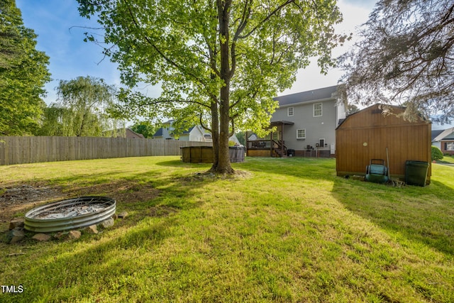 view of yard with fence, a storage unit, and an outdoor structure