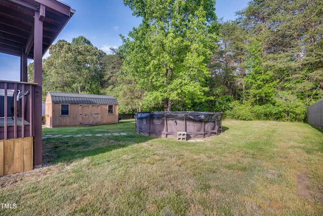 view of yard with a storage shed, an outbuilding, and a covered pool