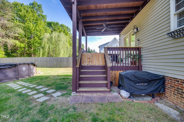 view of yard with a fenced backyard, ceiling fan, a deck, and stairway