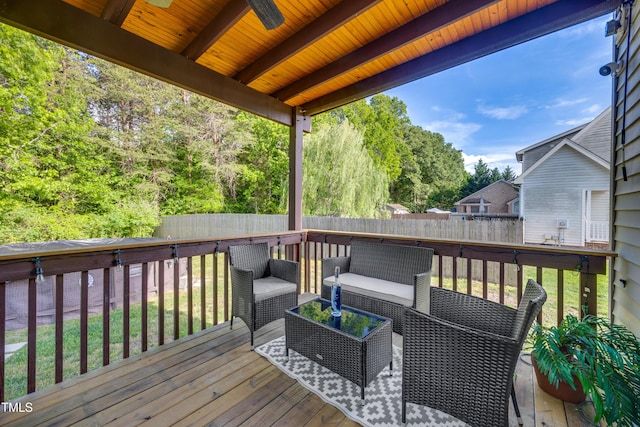 wooden terrace featuring ceiling fan, an outdoor living space, and a fenced backyard