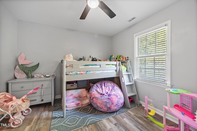 bedroom featuring a ceiling fan, baseboards, visible vents, and wood finished floors
