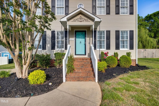doorway to property with a yard and fence