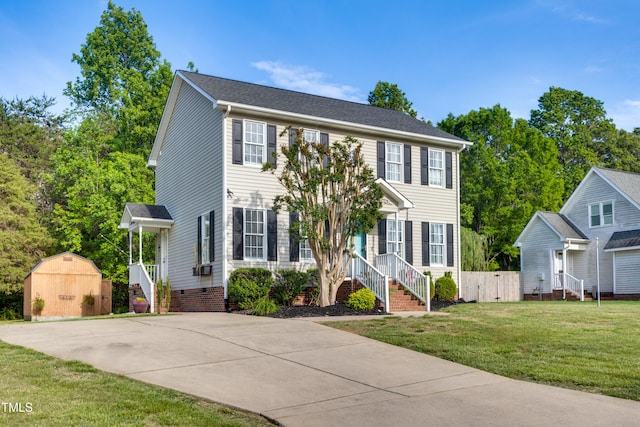 colonial home with a storage shed, an outbuilding, and a front yard