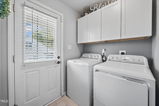 laundry room with cabinet space, a textured ceiling, and washing machine and dryer