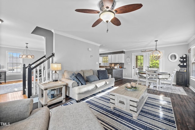 living area with baseboards, ornamental molding, a healthy amount of sunlight, and dark wood-type flooring