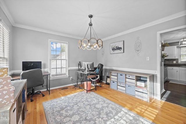 office area with crown molding, plenty of natural light, wood finished floors, and a notable chandelier