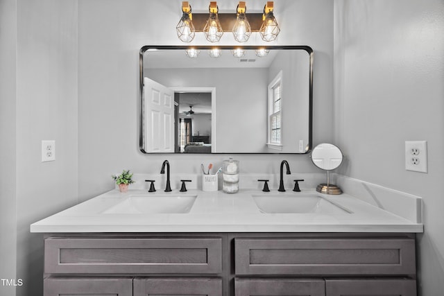 ensuite bathroom with double vanity, ceiling fan, a sink, and ensuite bath