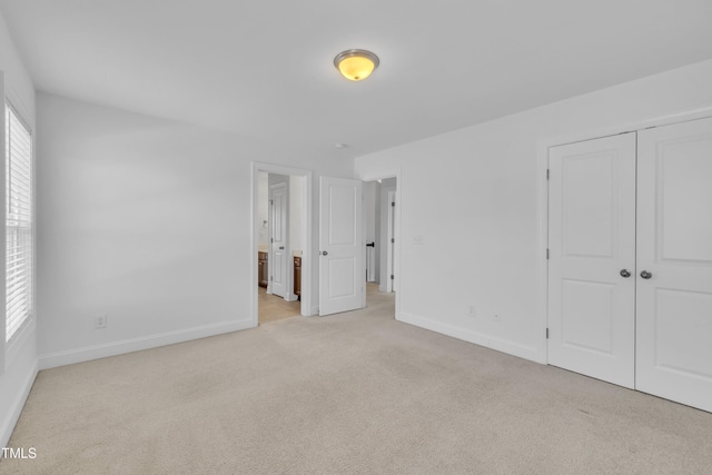 384 Grey Hawk Dr, Garner, NC 27529 - unfurnished bedroom with light colored carpet, baseboards, a closet, and ensuite bath