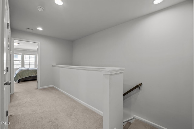 hall with an upstairs landing, baseboards, carpet, and recessed lighting