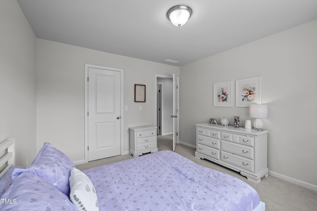 bedroom featuring light carpet and baseboards