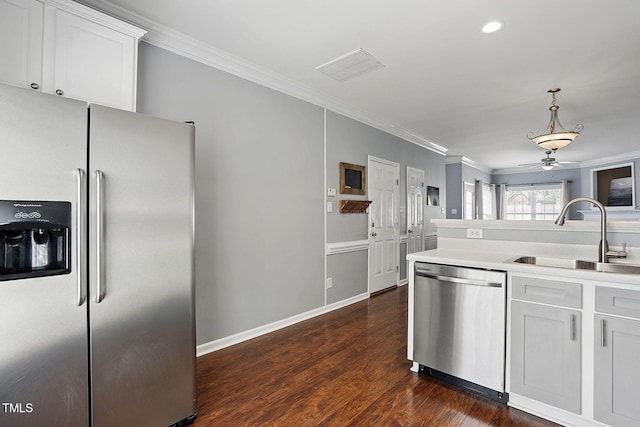 kitchen featuring a sink, crown molding, light countertops, appliances with stainless steel finishes, and dark wood-style floors