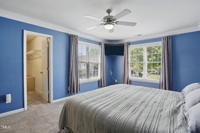 carpeted bedroom with baseboards, visible vents, crown molding, and a ceiling fan